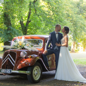 Photo de mariés sur leur voiture de mariage
