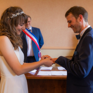 Photo de mariés qui s’échangent leurs alliances à la mairie