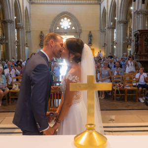 Photo des mariés s'embrassant pendant la cérémonie à l'église